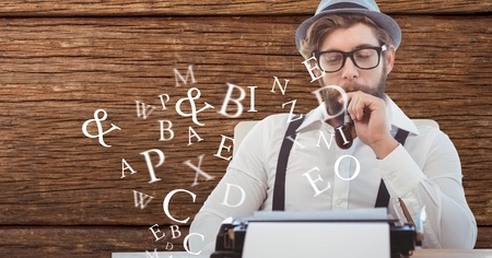 Digital composite of Hippie businessman smoking pipe while using type writerの写真素材