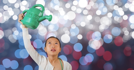 Digital composite of Little girl holding watering can over blur backgroundの写真素材