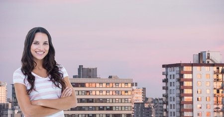 Digital composite of Happy woman with arms crossed in cityの写真素材