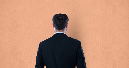Digital composite of Rear view of businessman over orange backgroundの写真素材