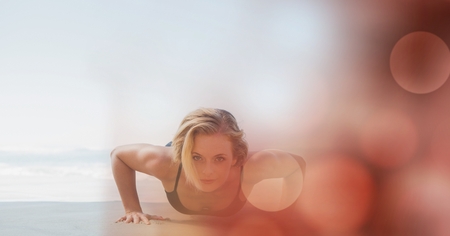 Digital composite of Woman doing push ups at beachの写真素材