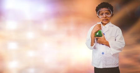 Digital composite of Portrait of boy doing scientific experiment over blur backgroundの写真素材