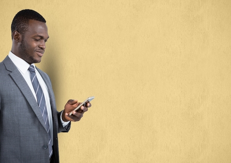 Digital composite of Businessman using mobile phone over beige backgroundの写真素材