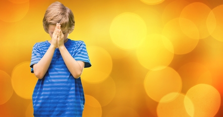 Digital composite of Boy praying against bokehの写真素材