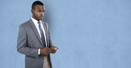 Digital composite of Thoughtful businessman holding smart phone against blue backgroundの写真素材