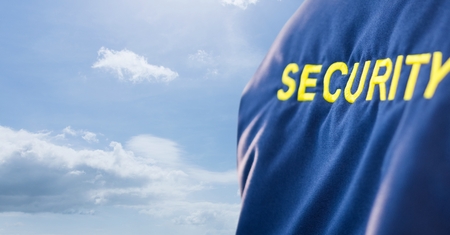 Digital composite of Security text on uniform against skyの写真素材