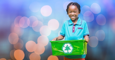 Digital composite of Portrait of happy boy carrying recycle basket over bokehの写真素材