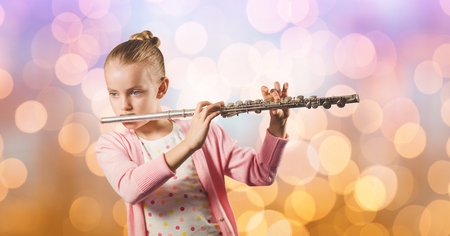Digital composite of Girl playing flute over bokehの写真素材