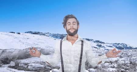 Digital composite of Double exposure man meditating with snow covered mountain in backgroundの写真素材