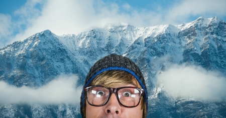 Digital composite of Surprised hipster against snow covered mountains
