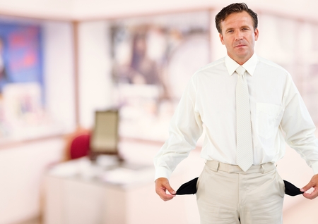 Digital composite of Mature businessman showing empty pocketsの写真素材