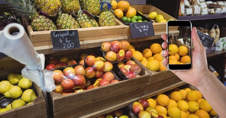 Digital composite of Hand photographing fruits through smart phone