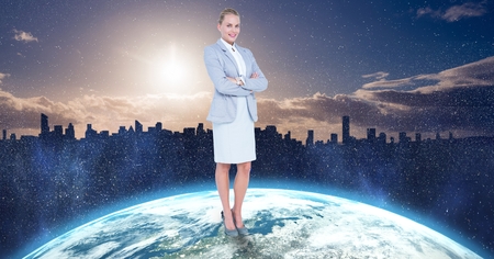 Digital composite of Businesswoman standing on globe against cityの写真素材