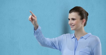 Digital composite of Smiling businesswoman pointing over blue backgroundの写真素材