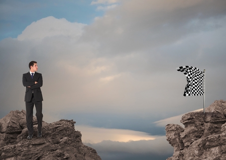 Digital composite of Businessman looking at checked flag against skyの写真素材