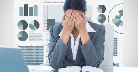Digital composite of Stressed businesswoman covering face with hands against graphsの写真素材