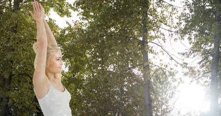 Digital composite of Double exposure of woman with hands clasped against trees