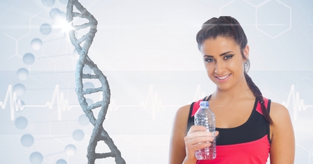 Digital composite of Fit woman holding water bottle against DNA structureの写真素材