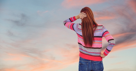 Digital composite of Rear view of redhead woman against skyの写真素材