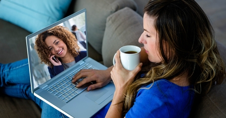 Digital composite of Young woman video conferencing on laptop while having coffee