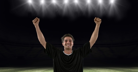 Digital composite of Successful soccer player with arms raised at stadiumの写真素材