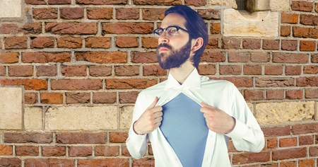Digital composite of Hipster tearing shirt against brick wallの写真素材