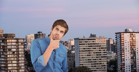 Digital composite of Thoughtful businessman with hand on chin against city
