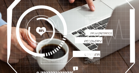 Digital composite of Top view of hand using laptop while holding coffee cup on table with overlays