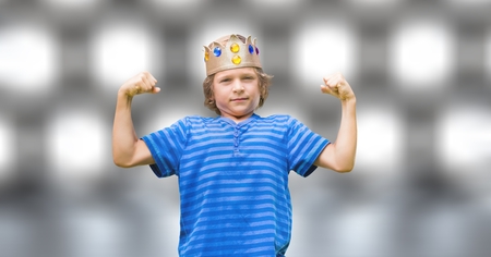 Digital composite of Portrait of confident boy in king crown flexing muscles over bokehの写真素材