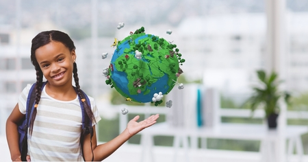 Digital composite of Smiling schoolgirl with low poly earthの写真素材