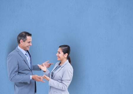 Digital composite of Happy business people talking against blue backgroundの写真素材