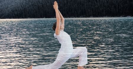 Digital composite of Double exposure of woman performing yoga by lakeの写真素材