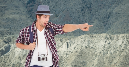 Digital composite of Excited traveler pointing while standing on mountainの写真素材