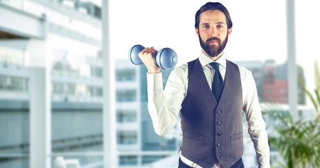 Digital composite of Confident man lifting dumbbell in cityの写真素材