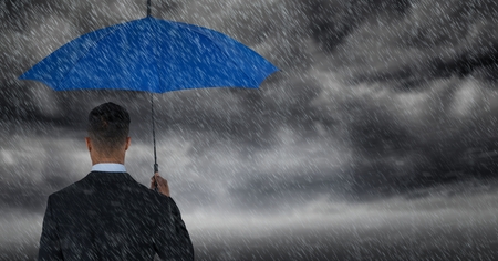 Digital composite of Back of business man with umbrella against storm clouds with rainの写真素材