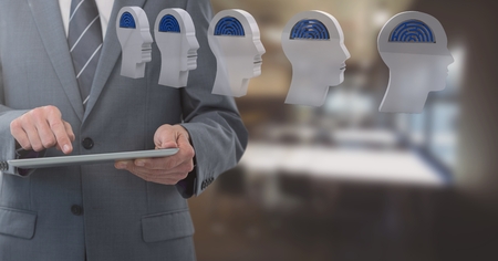 Digital composite of Businessman holding tablet with brain maze heads  in office