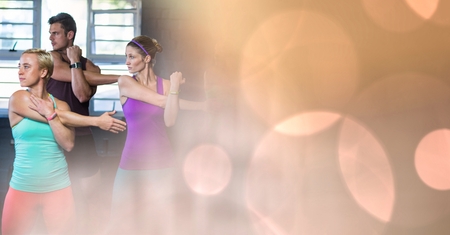 Digital composite of People stretching in gym and peach bokeh transition