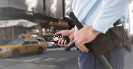 Digital composite of Security guard mid section against blurry streetの写真素材