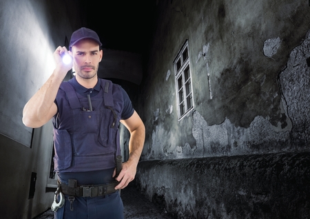 Digital composite of security guard in a alley at night with torchの写真素材