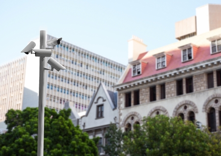 Digital composite of CCTV stick in front of blurred buildings during the dayの写真素材