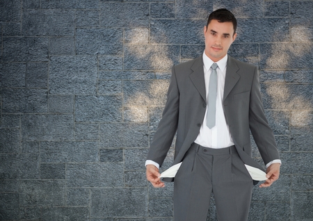 Digital composite of empty pockets businessman with rock wall background