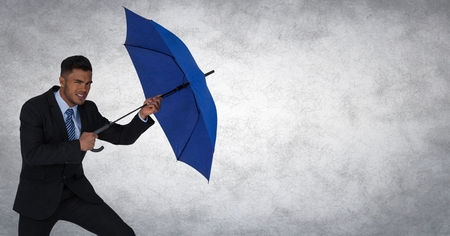 Digital composite of Business man blocking with umbrella against white background and grunge overlayの写真素材