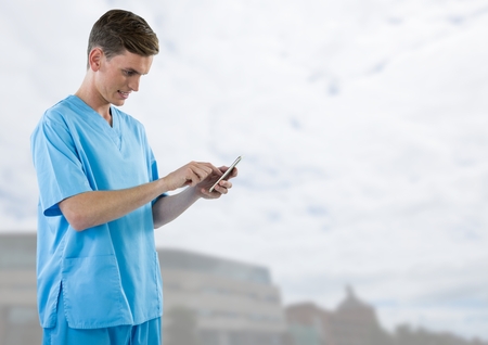 Digital composite of Doctor holding phone  with bright outside backgroundの写真素材