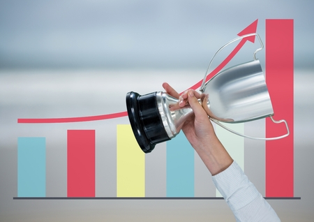 Digital composite of business hand with trophy.blue blurred background with graphic about grow upの写真素材