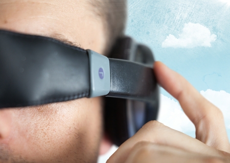 Digital composite of Close up of VR headset on man against sky