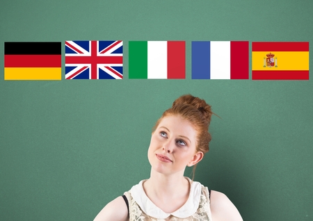 Digital composite of main language flags over young woman thinking. Green backgroundの写真素材