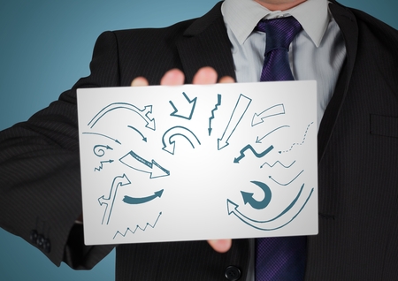 Digital composite of Business man mid section with card showing blue arrow doodles against blue backgroundの写真素材