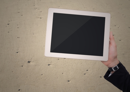 Digital composite of Hand with tablet against sandの写真素材