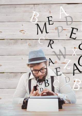 Digital composite of Hipster man with a pipe reflecting on his typewriter in front of wood wallの写真素材
