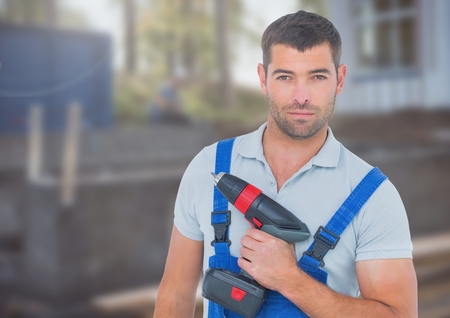 Digital composite of Carpenter with drill on building siteの写真素材